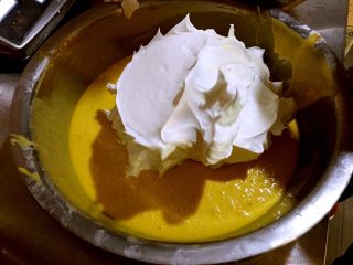 5、最靠谱的网红-蛋糕店里的肉松小贝,取三分之一的蛋白霜加入蛋黄糊里，用刮刀翻拌使之均匀，不要画圈搅拌，易消泡。