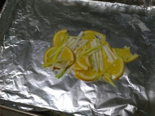 5、柠檬烤鲈鱼,在烤盘中间铺一层葱姜柠檬