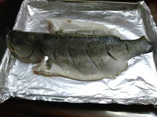 6、柠檬烤鲈鱼,把鱼趴在柠檬上面，鱼身上刷一层食用油