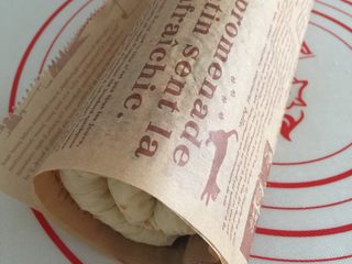 21、香葱肉松面包卷(65度汤种法),借助擀面杖卷起来,卷法:将擀面杖放在靠近自己身体这边的油纸下面开始卷起来,最后把擀面杖卷进去收紧定型