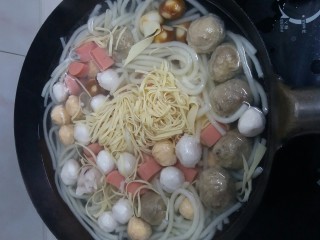 5、年轻人的米线,将准备好的鱼丸香肠和豆腐放进去,这个时候可以用筷子扒拉了。