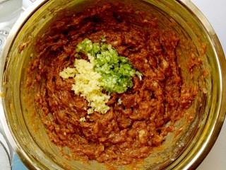 15、独家红烧狮子头四喜丸子配方,把葱碎，姜碎倒入搅完200圈的肉泥中