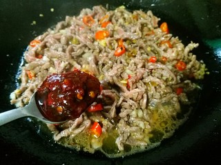 14、爆炒牛肉丝,加1勺豆瓣酱翻炒均匀。