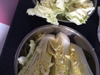 1、家庭版辣白菜,如图白菜切成四瓣每片根部摸盐加温热水用重物压住一夜
