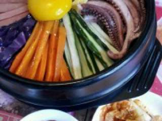 4、韩国石锅拌饭,装出适量的辣椒酱和泡菜，石锅上火烤到发出“吱吱”声为宜。