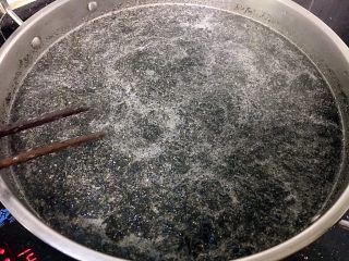 9、田艾印粿,加入三分之一的黑芝麻碎,田艾、搅匀,煮开,最后加入适量的玉米油,关火!