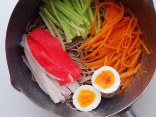 3、一人食|懒人版凉拌荞麦面,荞麦面放入雪平锅后，铺上青瓜丝，过水的胡萝卜丝、撕成条状的蟹柳，放入横切成两半的鸡蛋，8分熟的蛋黄，看着就忍不住想一口吃掉；