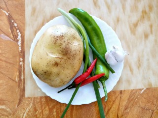 1、酸辣土豆丝,准备好土豆，葱，小米红椒，青椒，蒜头
