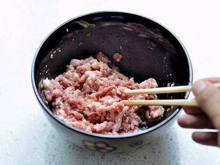 1、香煎茄盒,猪肉馅里洒上姜末、调进精盐、酱油用力顺一个方向搅拌上劲儿腌渍入味。
