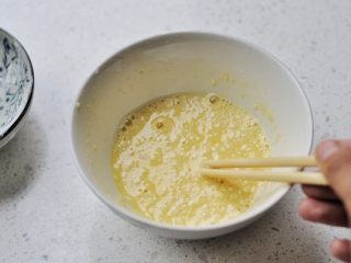 2、香煎茄盒,鸡蛋磕入小碗,倒进面粉,加入少许的清水搅拌成粘稠的鸡蛋糊,面糊的粘稠度能挂住筷子就可以。