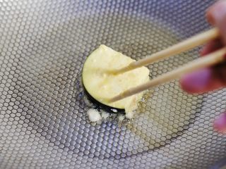 7、香煎茄盒,炒锅里倒入油,把做好的茄子夹裹上鸡蛋面糊放进炒锅。