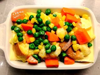 7、时蔬芝心面包布丁,将剩余的吐司丁全铺上,剩余蛋奶液均匀淋在吐司丁上。剩下的时蔬也均匀的洒在表面????小贴士:这里多余的蛋奶液一定要倒进来哦,烤好了就是幼嫩的布丁