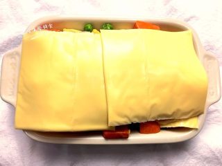 8、时蔬芝心面包布丁,在顶层铺上芝士片,最好铺满。送入烤箱170度烤25分钟,看到顶层芝士融化。