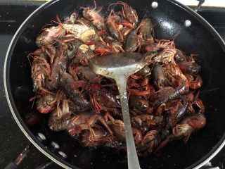 4、红烧小龙虾,放入生抽，盐和白糖继续翻炒2分钟左右。