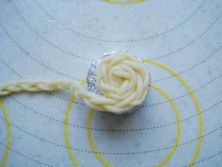 9、草帽编织饼干,锡纸包好的胡萝卜小段表面抹一层水，能更好的粘贴上小辫子，把小辫子围绕着萝卜缠绕，做草帽顶部。