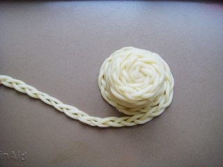 10、草帽编织饼干,缠绕好后放入烤盘，接着缠绕做草帽的帽檐。（每根辫子的接口处用水沾好）