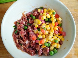 4、什锦祈福虾,将胡萝卜粒，甜玉米粒和豌豆入开水焯熟后加入搅拌好的肉馅中，和肉馅拌匀成什锦肉馅。