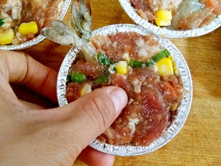 6、什锦祈福虾,再在虾上面铺上什锦肉馅，中间用手指按一个小凹印。