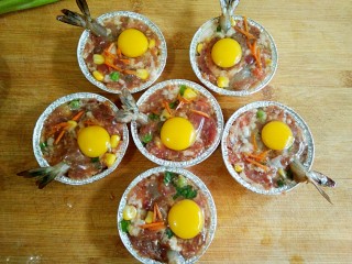 7、什锦祈福虾,打上鹌鹑蛋，蛋黄位于凹印内，再撒上少许胡萝卜碎。