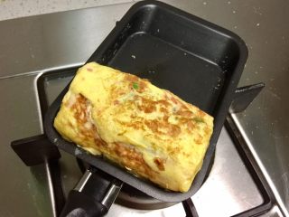 9、香葱火腿厚蛋烧,反复煎蛋皮,再卷起,至所有蛋液用完。