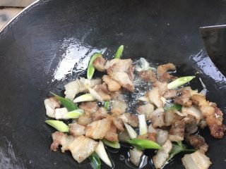 3、辣椒炒回锅肉,热锅加底油，然后小火先煎五花肉，待两边煎至金黄色后将辣椒，盐，鸡精，生抽依次放入，大火开炒，再放青蒜叶翻炒，之后加一小勺水收汁，煮一分钟左右即可