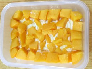 13、水果便当蛋糕,摆上一层芒果粒，规整的尽量放四周一圈，中间放些碎粒即可。