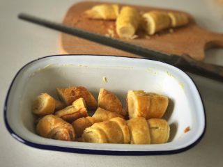 1、雜莓竪果可頌布丁,烤箱預熱上下火180度，可頌切塊放入抹了黃油的烤盤里