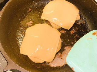 8、家庭版芝士牛肉汉堡,准备好四片芝士，分别两片各盖在煮好的牛肉上小火慢慢煎至融化，就可以把牛肉出锅、放在准备好的汉堡材料上了