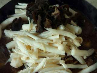 5、家庭版焖锅鸡肉,待水差不多炖到一半干的时候，倒入海鲜菇，木耳焖。