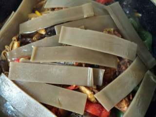 7、家庭版焖锅鸡肉,最后把粉皮铺在鸡肉表面，盖上锅盖焖。不要翻炒，否则粉皮容易糊锅底，影响菜的品相。