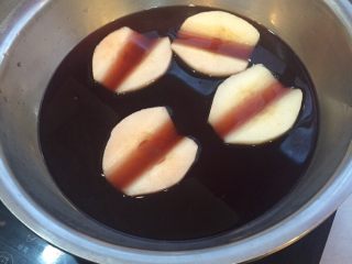 3、清肺润喉甜品---红酒雪梨,将雪梨放入汁中 加热烧开
