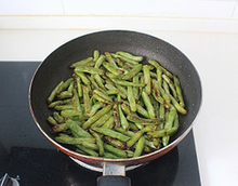 5、干煸四季豆,中小火半煎半炸将四季豆至四季豆两面都出现虎皮。