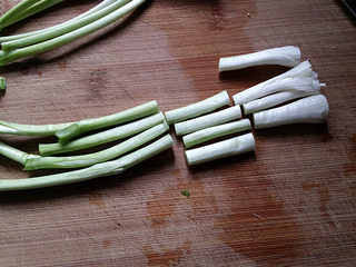 3、青蒜炒胡萝卜,青蒜切根剥去外皮后洗净、先用刀背将蒜头部分拍松散，然后将蒜白、蒜叶切寸段