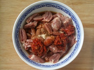 3、下饭又下酒的辣椒酱爆鸡心,把鸡心放碗中，(我喜辣)加2匙辣椒酱，白糖，白胡椒粉和酱油，料酒拌匀，腌制20分钟左右至入味。(辣椒酱根据个人喜好来决定放多少)