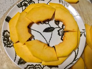 6、#吉祥年菜#金银满屋福满仓~椰香南瓜蒸银耳,取喜欢的盘子把南瓜片摆成圆形，一层一层的直到摆完所有南瓜片