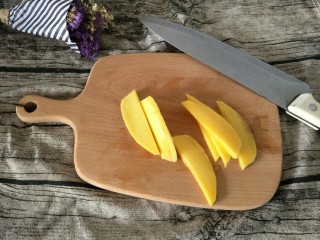 15、#网红甜点DIY家庭手做#芒果花思慕雪碗,切成薄薄的芒果片，尽量切薄一点