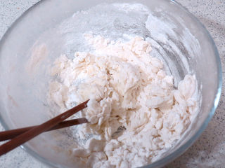 11、花儿朵朵之【双色培根烧卖】 ,来做白色的面团。两种粉放到容器里，拌匀，缓缓加入热开水，一边倒一边用筷子搅拌