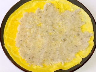 9、宝宝辅食之虾仁莲藕蛋卷,蛋饼上均匀铺上虾泥馅料，用勺子压紧压实。
