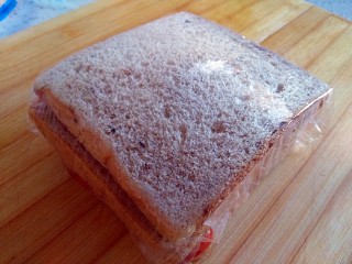 8、元气早餐之能量三明治,用保鲜膜将做好的三明治包紧