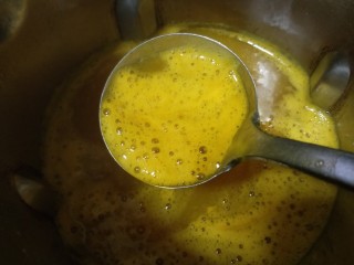 10、养生美颜甜品——玫瑰南瓜银耳露,煮好的银耳露金黄色的，由于加了银耳，有些泡泡，用个勺子撇去不要