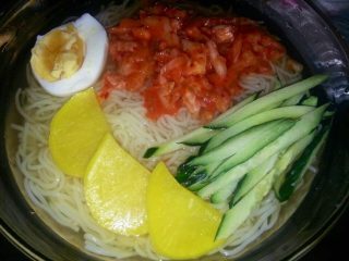 5、王氏冷面,取出适量的牛骨汤'加入酱油、米醋、白糖、盐、香油'把荞麦面从水中捞出放入加好料的牛肉汤里'摆上黄瓜丝辣白菜黄萝卜半个熟鸡蛋