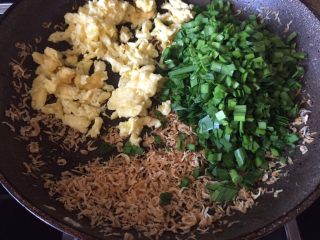 2、荞麦韭菜盒子,倒入虾皮，韭菜，翻炒；