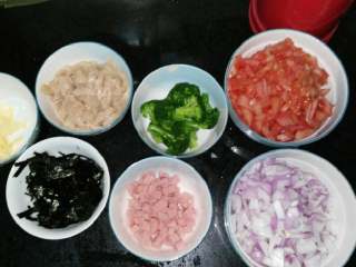 1、鸡肉番茄芝士焗饭,准备食材洋葱，番茄，芝士，花菜，火腿肠，鸡肉，分别切块。(海苔最后铺在上面，可不用的)