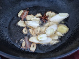 7、红烧鲳鱼,就锅中底油放入葱、姜、蒜、八角和桂皮小火炒香