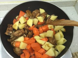 3、新疆大盘鸡,放入土豆和胡萝卜翻炒均匀