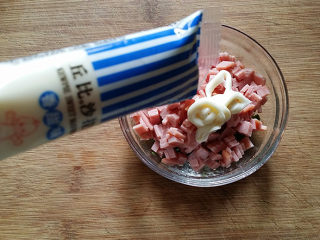 9、香葱火腿面包卷,趁松驰的时间，可将火腿片切小粒放入香葱碗中，再挤入适量沙拉酱，拌匀备用