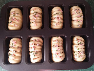 14、香葱火腿面包卷,出表面刷全蛋液，将前面预留的香葱火腿碎均匀地撒在面包坯表面