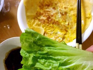 6、鸡蛋卷饼,面皮熟后盛出装盘，洗好生菜，拿出熬好的酱。