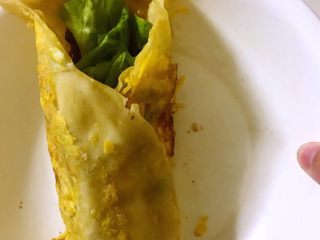 7、鸡蛋卷饼,酱刷在没有鸡蛋那面，放上生菜，也可以放其他食材，看个人喜好，摆好后卷起来，就可以开吃啦！