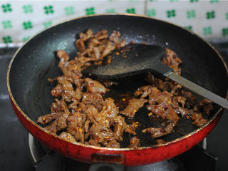 11、孜然羊肉,放入辣椒粉、孜然粉、花椒粉翻炒均匀